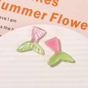 Macro shot of glittery gradient pink and green resin mermaid tails for DIY crafts