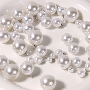 Polished white pearl pendants in various sizes with silver metal loops for DIY jewelry
