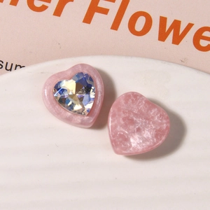 Close-up of pink heart resin charms with crystal inlay and marble texture on white tray