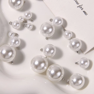 Macro view of ivory pearl pendants with silver metal loops in various sizes for DIY jewelry