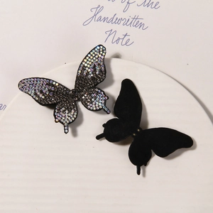 Detail of 3D butterfly charms with iridescent rhinestones and black velvet textures