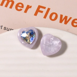 Macro shot of lilac pearlescent resin heart with sparkling crystal for DIY jewelry
