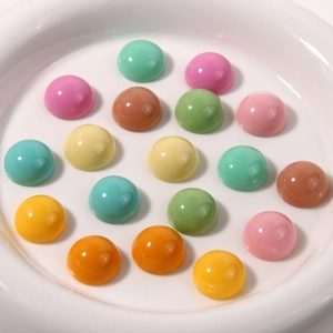 Primo piano di cabochon in resina lucida dai colori vivaci su un vassoio di ceramica