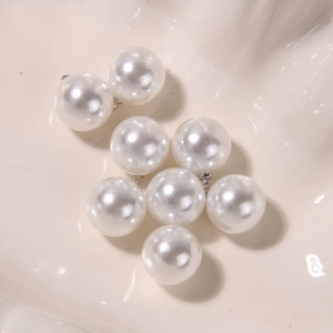 Macro shot of white round lustrous pearls with silver metal loops for DIY jewelry making