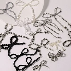 Detailed view of handmade pearl bow charms and silver bead accessories for DIY footwear