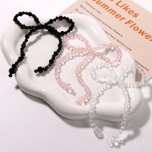 Detailed view of faceted crystal bow beads in black, pink, and transparent white colors