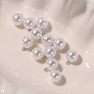 Macro shot of white round pearl charms with silver ring connectors for DIY jewelry making