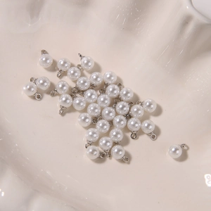 Macro detail of high-luster white pearl pendants with silver metal bails for DIY jewelry