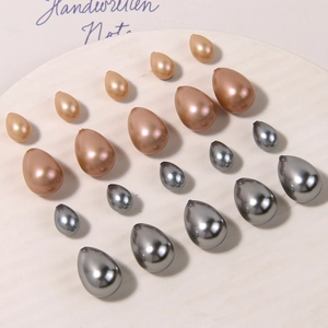 Champagne and grey teardrop faux pearls set in various sizes on a white display plate