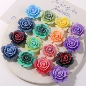 Macro detail of rainbow glitter rose charms for DIY jewelry and hair accessory crafts