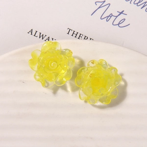 Vue macro de boucles d'oreilles rose en résine jaune avec feuille d'or sur plat