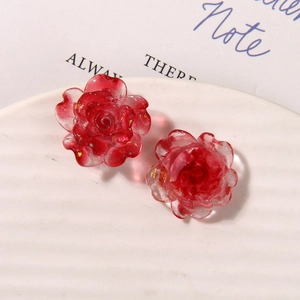 Détail de breloques roses en résine rouge translucide avec feuilles d'or pour bijoux