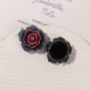 Macro detail of sparkly rainbow resin rose charm showing matte texture and flat back design