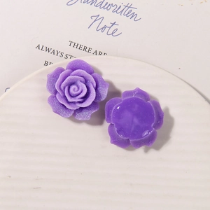 Detail macro view of purple resin rose charms with glitter texture for DIY jewelry making