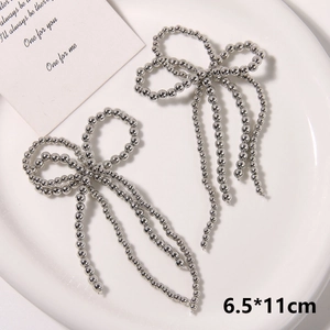 Detailed close-up of handmade pearl bow charms with long tassels for shoe accessories