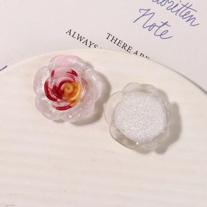 Dettaglio di rosa in resina rosa e camelia glitterata per gioielli fai-da-te e accessori