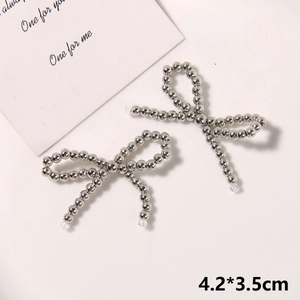 Detailed macro view of handmade silver bead bow shoe charms measuring 4.2x3.5cm size