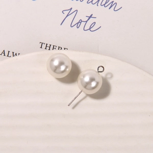 Detailed view of matte white pearl bead with silver metal pin for DIY jewelry making