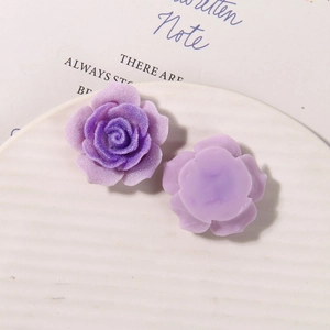 Macro shot of purple gradient resin rose charms with glitter finish for DIY crafts