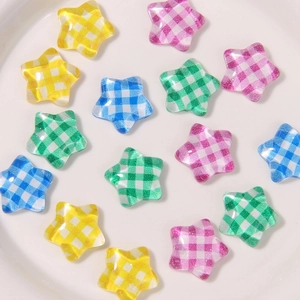 Macro shot of colorful glitter resin star charms with gingham pattern on white surface