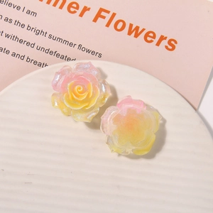 Close-up of glittery resin rose flower charms in pink gradient for DIY hair accessories