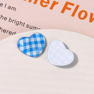 Detail view of blue checkered resin heart charms for DIY jewelry and hair accessories