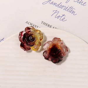 Close-up of translucent luminous resin rose charms with purple and red gradient finish