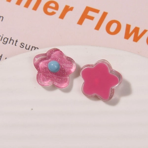 Detail von rosa Harzblumen-DIY-Anhängern mit Glitzer und blauer Perle für Schmuck