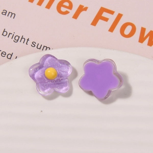Makroaufnahme von lila Blumenanhängern aus Harz mit Glitzer und mattem Finish für DIY-Basteln