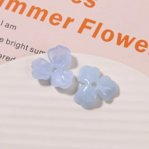 Makro-Detail von lichtblauen Acryl-Blütenperlen mit drei Blättern für DIY-Schmuckherstellung
