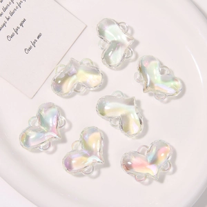 Dettaglio di sette ciondoli a cuore in resina iridescente con anelli per gioielli DIY