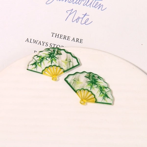 Detailed macro view of DIY acrylic fan pendants with bamboo patterns and pre-drilled holes