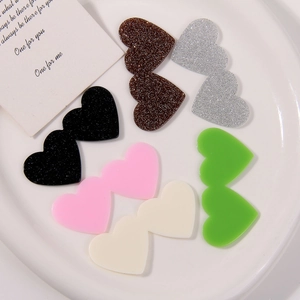 Close-up of double heart acrylic charms in glitter and solid colors for DIY crafts