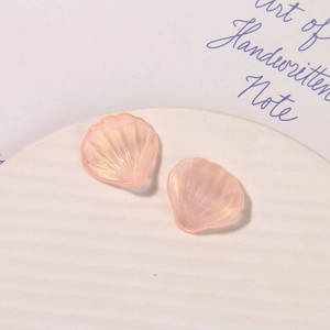 Macro shot of pearlescent pink scallop shell resin charms for DIY craft accessories
