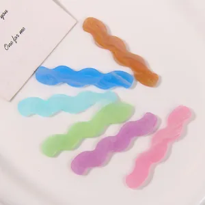 Macro shot of wavy colorful marble acrylic hair clip charms in six summer pastel shades