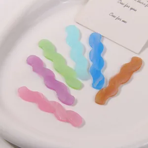 Macro shot of wavy candy-colored acrylic resin pieces for DIY hair accessories