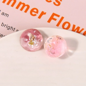 Detail of pink resin DIY shoe charms with gradient ocean shells and dried flowers