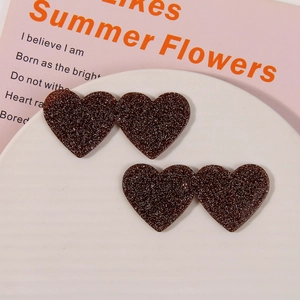 Close-up of heart-shaped brown glitter resin hair clips on a white display tray