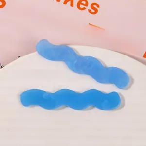 Close-up of wave-shaped blue acrylic hair clips with marble texture on white tray