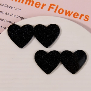Detail of double heart acrylic accessories with black glitter finish for DIY crafts
