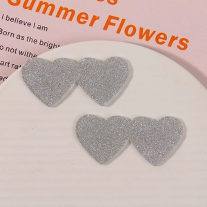 Close-up of shiny silver glitter acrylic double heart charms for DIY hair accessories