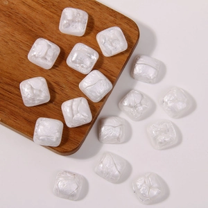 Macro shot of pearl white square resin beads with pearlescent marble texture for DIY jewelry