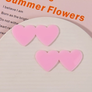 Detail showing two linked pink acrylic hearts for DIY hair accessories and crafts