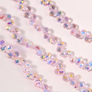 Close-up of faceted Aurora AB glass teardrop beads with iridescent rainbow reflections
