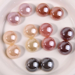 Colorful round acrylic cabochon beads for DIY jewelry making in a white ceramic dish