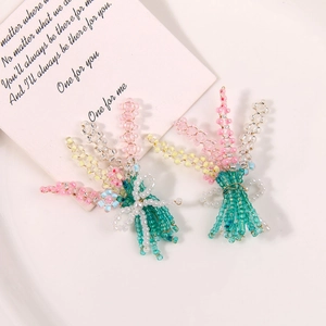 Detailed view of handmade beaded flower bouquet charms with white bowknot accents