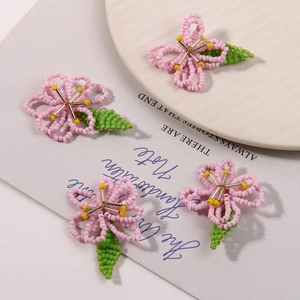 Detalle de flores de cuentas hechas a mano en rosa y verde para crear joyas de bricolaje