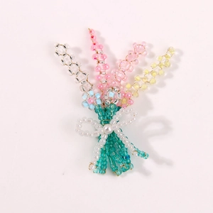 Macro view of handmade beaded flower bouquet hair clip with pearl center and white bow