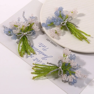 Detailed close-up of handmade beaded flower bouquet brooch with elegant silver bow tie