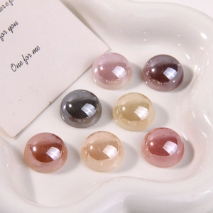 Macro shot of colorful flatback acrylic pearls for DIY jewelry making in a ceramic tray